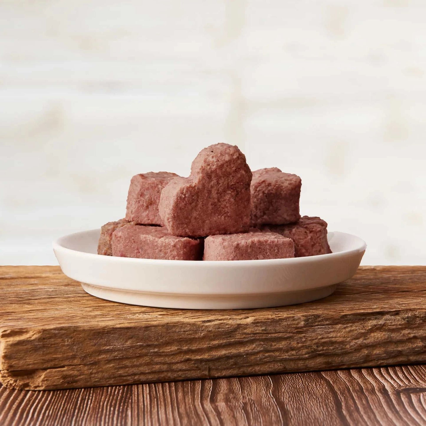 All-in-One Hundefutter Herzchen Rind auf weißen Teller, naturbelassene Zutaten, hochwertiges Protein und Nährstoffe.
