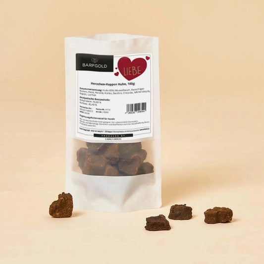 Herzchen-Happen Huhn, getrocknet. Platziert mit einzelnen Herzchen-Happen vor dem Produkt.