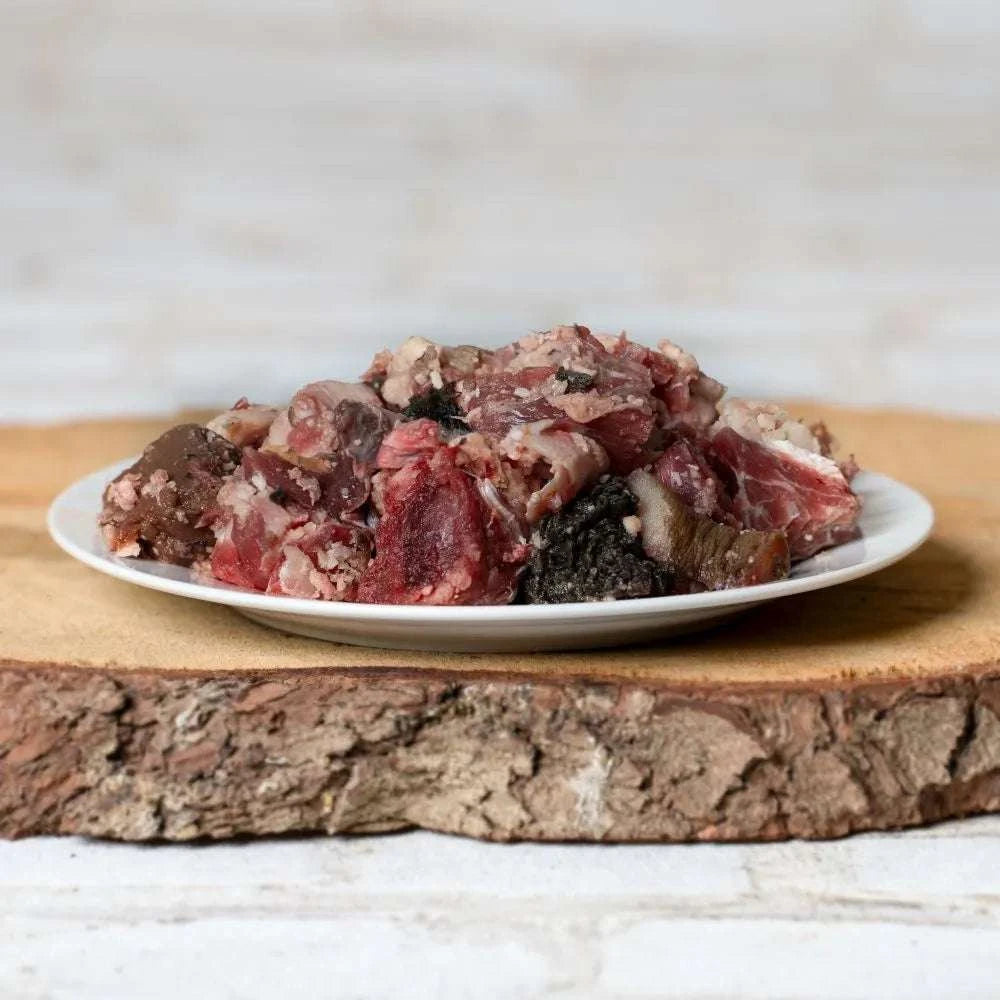 BARF-Fleischmenü vom Rind mit Knochenmus auf Teller, geeignet für Hunde ab 15 kg.