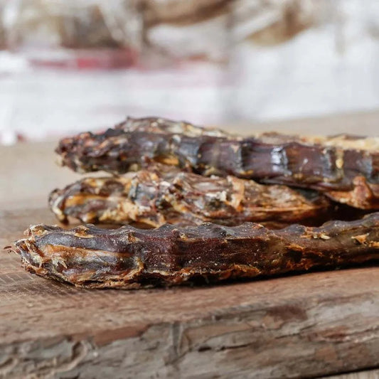 Entenhälse für Hunde und Katzen, platziert auf einem Holzbrett.