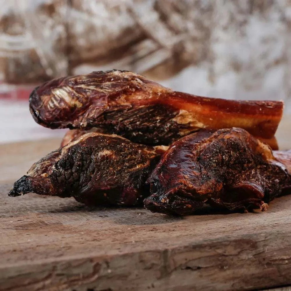 Getrocknete Fleischkeule 10-15 cm als Kaubeschäftigung für Hunde, platziert auf einem Holzbrett.