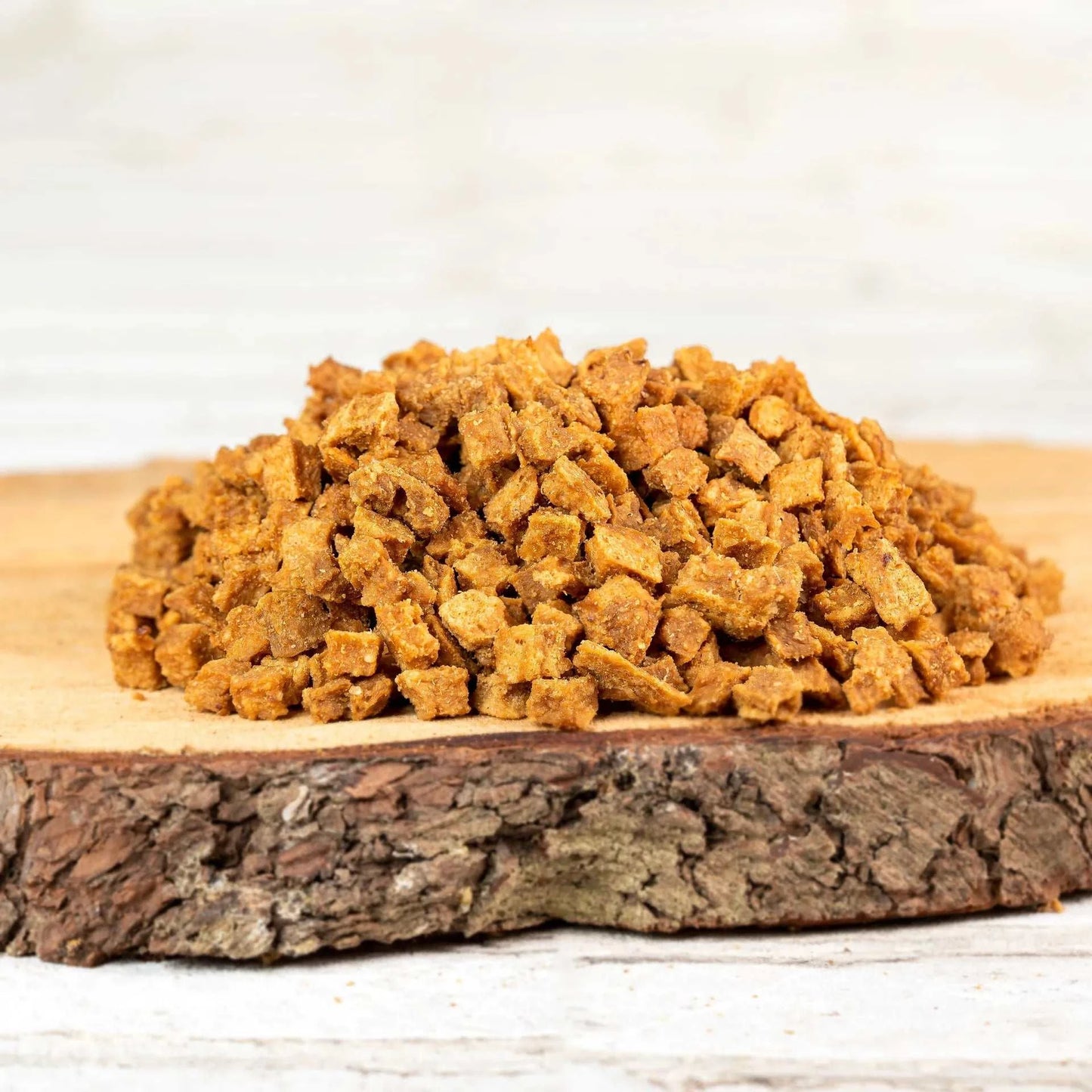 Putenfleischwürfel auf Holzbrett, 100 % reines Fleisch, ideal fürs Hundetraining.