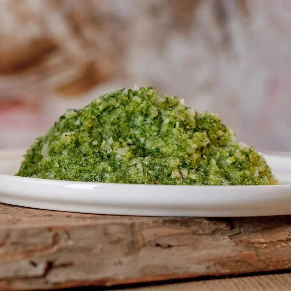 Grüner Gemüsemix, fein geraspelt auf Teller, reich an Vitamin D und E, erntefrisch.