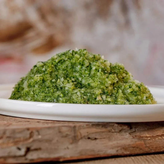 Grüner Gemüsemix, fein geraspelt auf Teller, reich an Vitamin D und E, erntefrisch.