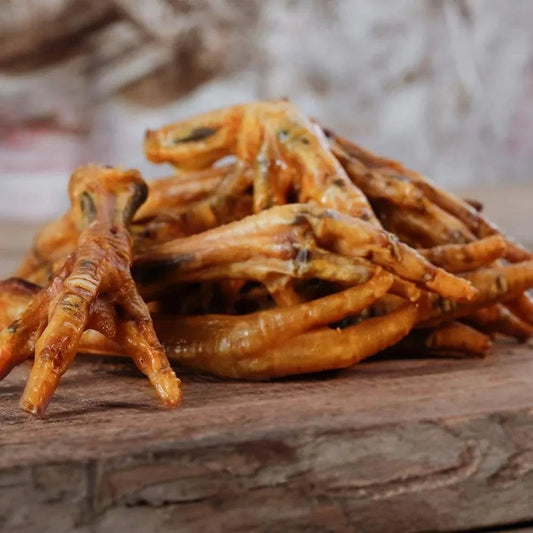 Hühnerfüße auf Holzbrett, leicht verdaulich, reich an Calcium, für Hunde und Katzen geeignet, Naturkauartikel.