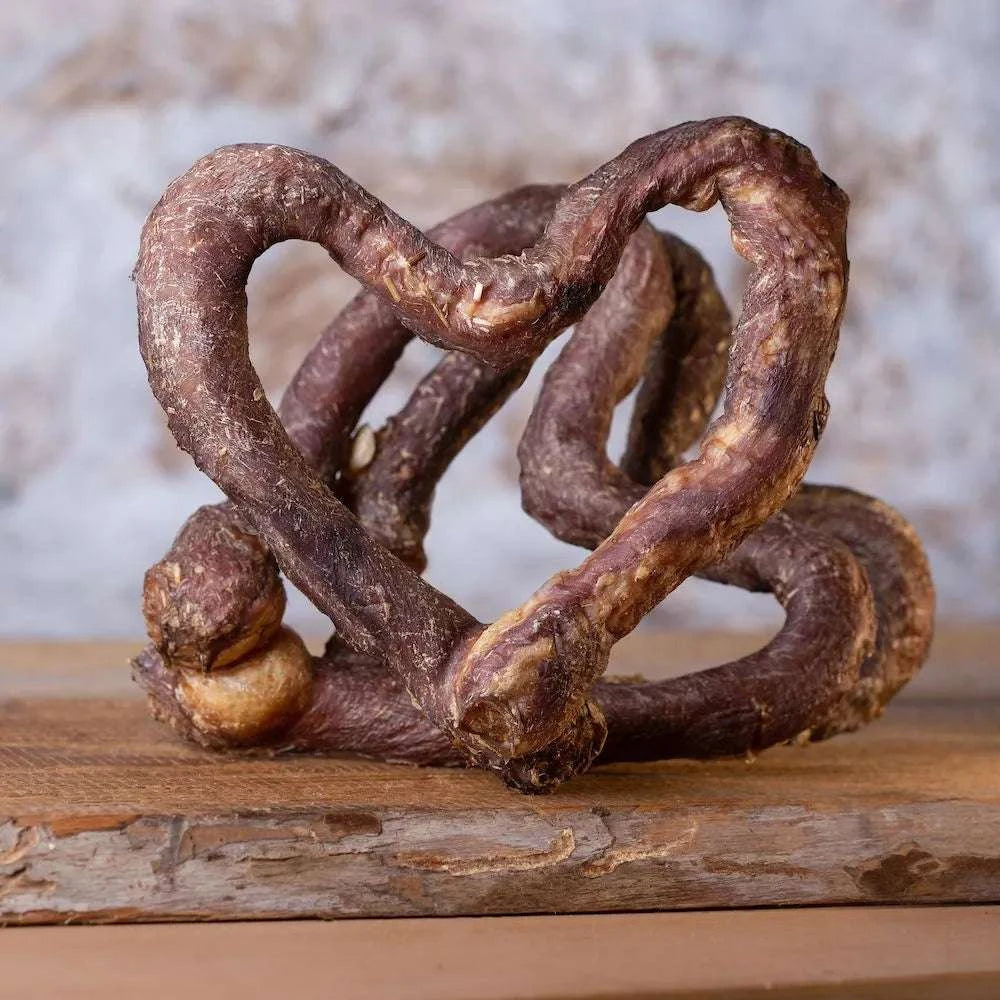 Kalbsschlund in Herzform platziert auf einem Holzbrett, getrocknet, Leckerbissen für Hunde.