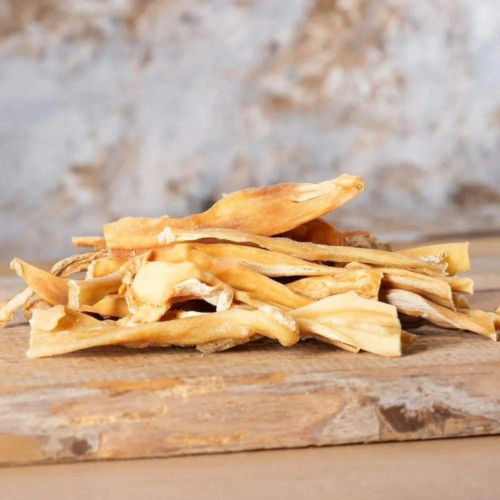 Getrocknete Lammkopfhaut auf einem Holzbrett, geeignet für kleinere Hunderassen und Allergiker.