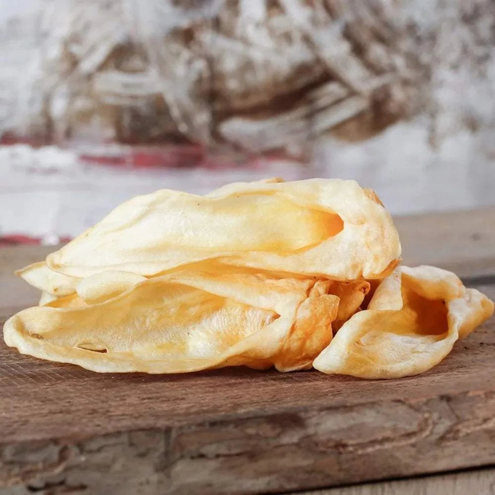 Getrocknete Lammohren ohne Fell, platziert auf einem Holzbrett.