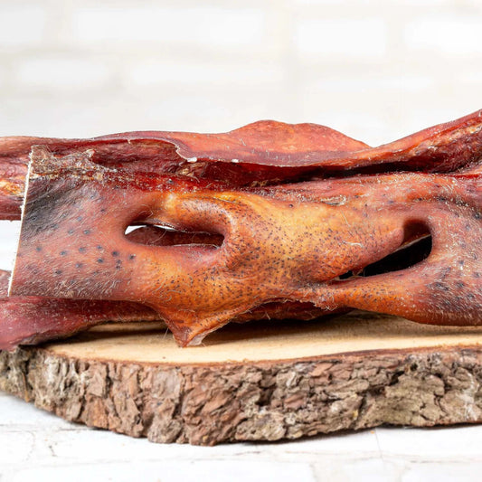 Ochsennasen Snack für Hunde auf Holzbrett, ideal zur Zahnpflege.