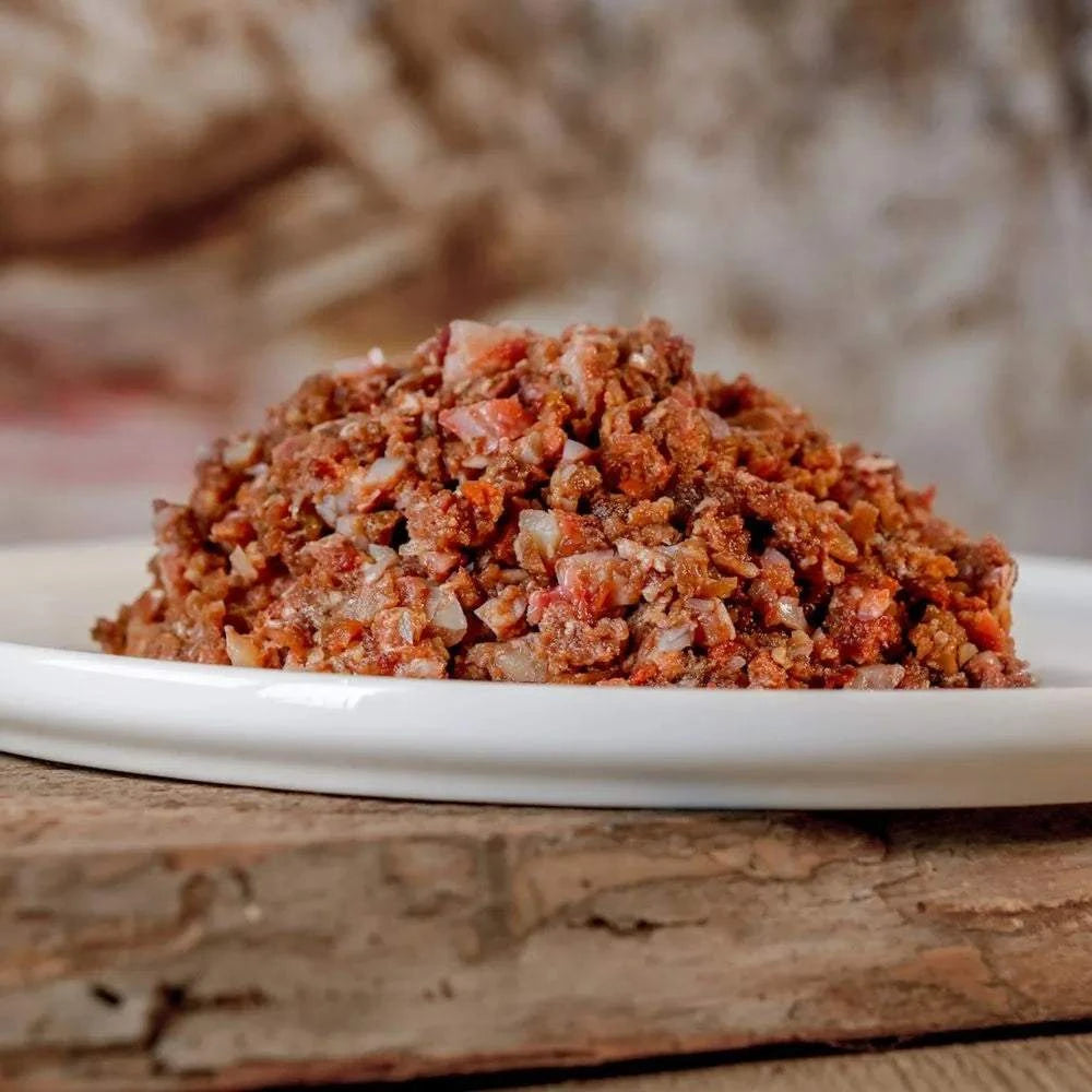 Barf-Komplett-Menü aus Pferdefleisch auf einem weißen Teller, ideal für Hunde mit Allergien, reich an Muskelfleisch und Gemüse.