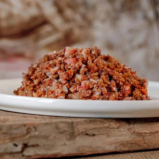 Barf-Komplett-Menü aus Pferdefleisch auf einem weißen Teller, ideal für Hunde mit Allergien, reich an Muskelfleisch und Gemüse.