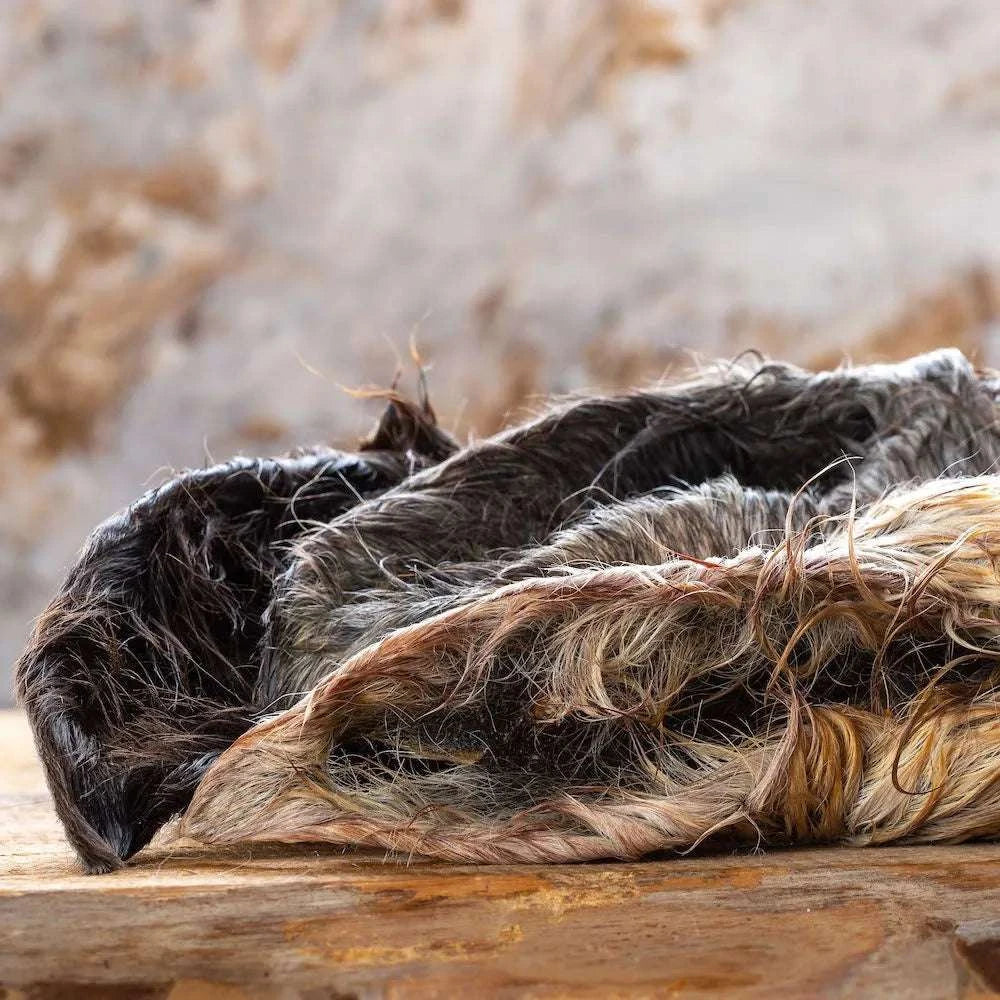 Pferdeohren mit Fell auf Holzbrett, ideal für allergische Hunde, fördert Zahn- und Darmreinigung.