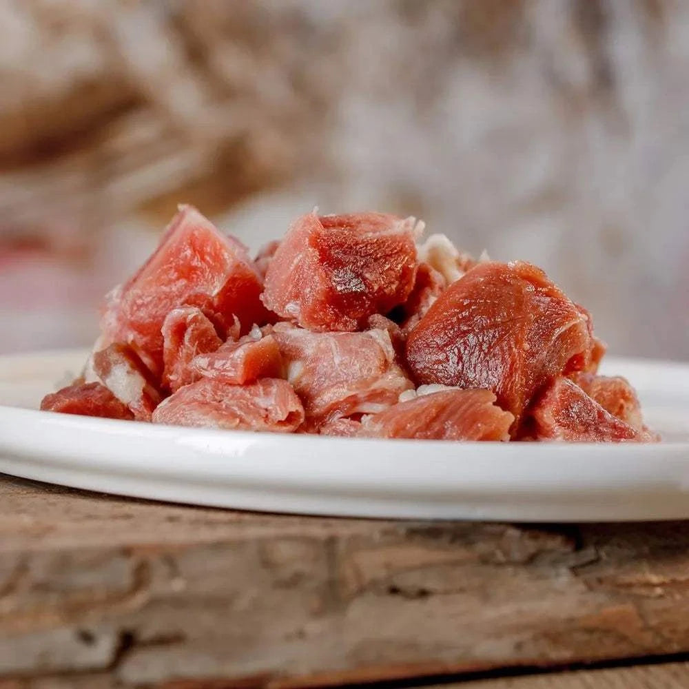 Putenmuskelfleisch auf weißem Teller, ideal für Hunde- und Katzenernährung.
