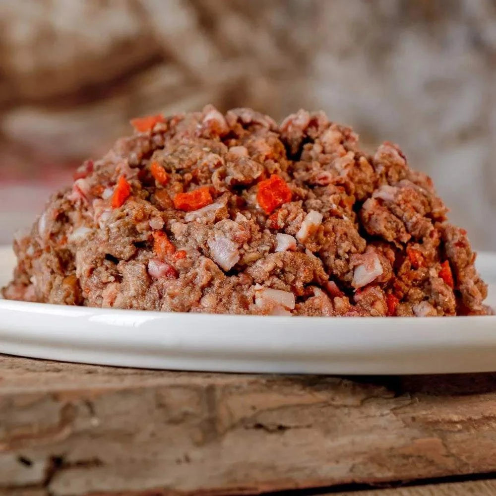 Rinder-Barf-Menü, gewolft, mit Gemüse und Früchten auf Teller.