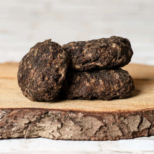 Rinderlungenfrikadelle für Hunde auf einem Holzbrett, naturbelassen und getrocknet.