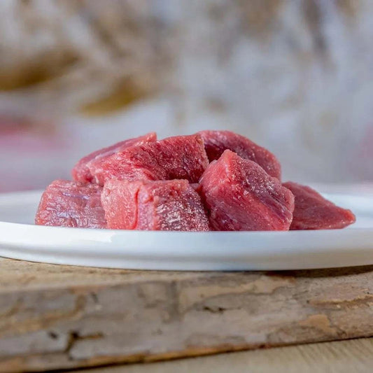 Mageres Rindermuskelfleisch auf weißem Teller, ideal für BARF-Hundeernährung.