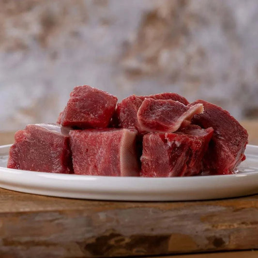Mager geschnittene Rinderzunge auf einem weißen Teller, ideal für BARF-Ernährung.
