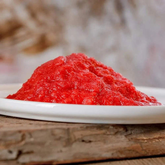 Feiner roter Früchtemix aus Apfel, Johannisbeere und Birne, frisch geraspelt auf einem Teller.
