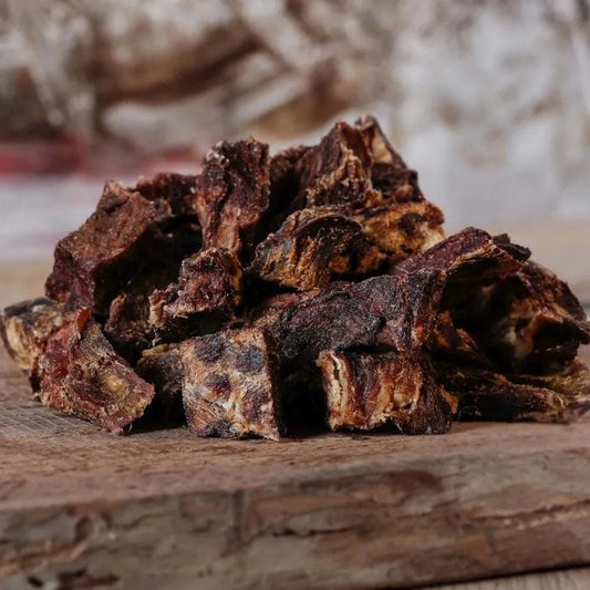Schmatzies Rindfleisch-Leckerlis für Hunde auf Holzbrett.
