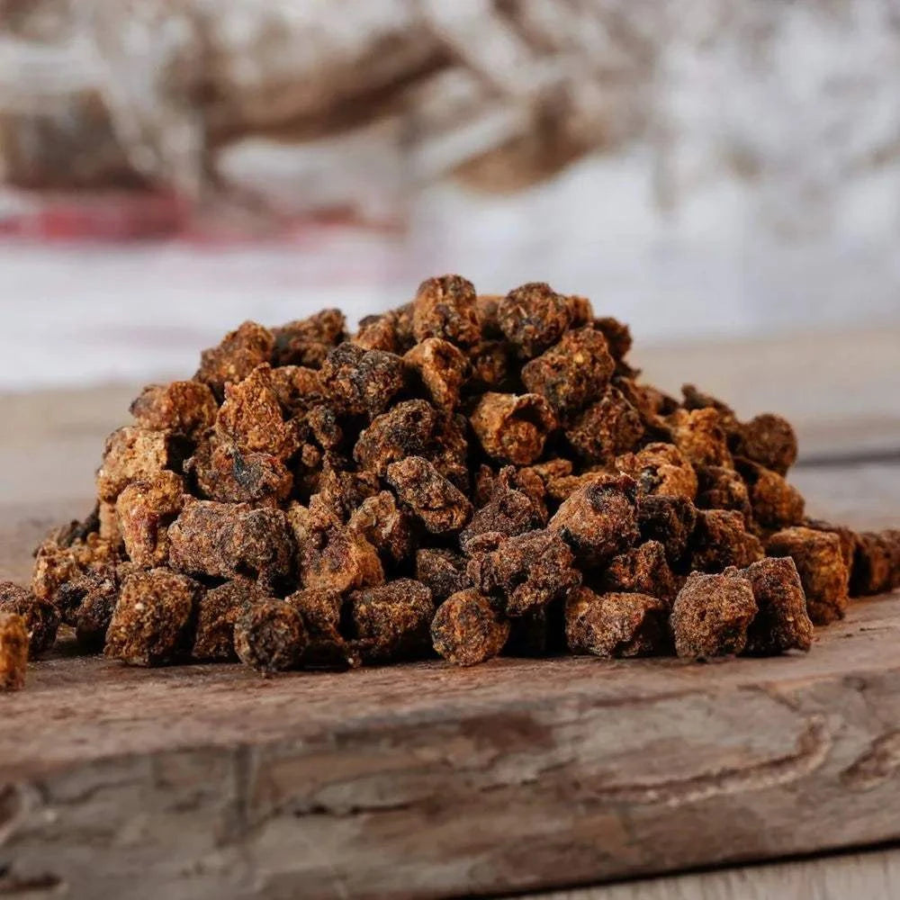 Trainingsdrops für Hunde aus pflanzlichen und tierischen Nebenerzeugnissen, platziert auf einem Holzbrett.