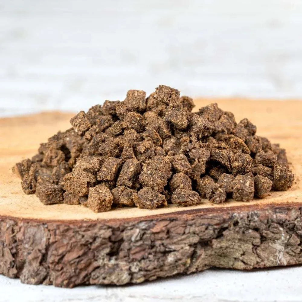 Pferdefleischwürfel auf Holzbrett als idealer Hundetraining-Snack.