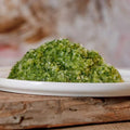 Grüner Gemüsemix, fein geraspelt auf Teller, reich an Vitamin D und E, erntefrisch.