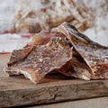 Knorpelplatten vom Rind für lange Kaubeschäftigung, platziert auf einem Holzbrett.