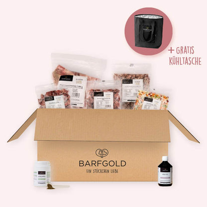Starterpaket Gourmet für Hunde mit Hirsch, Ente, Ziege und Ergänzungsfuttermitteln, inklusive gratis Kühltasche für frische Lagerung. Produkte des Starterpakets platziert in einer BARFGOLD-Versandbox.