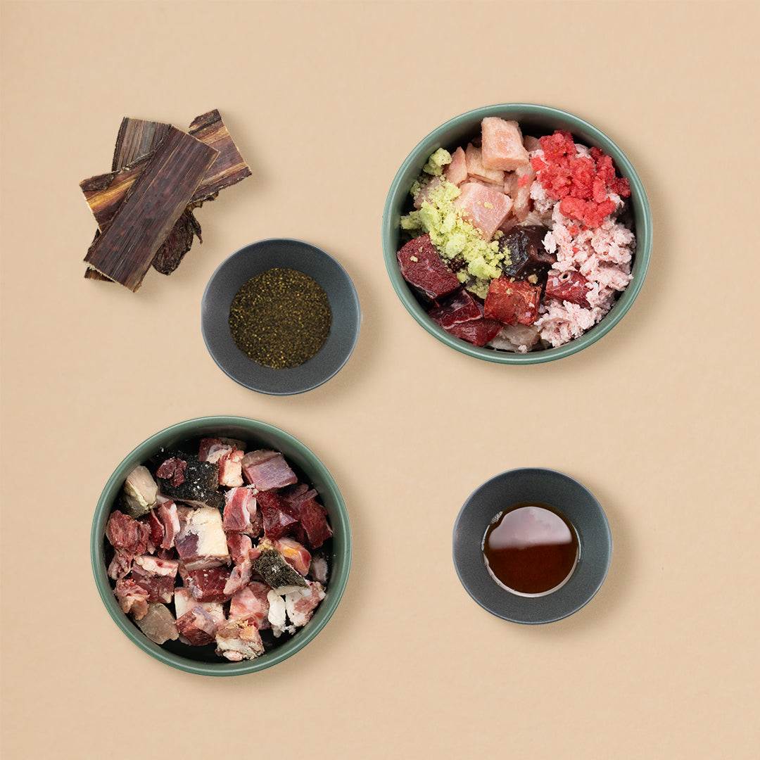 Starterpaket Classic Rind für Hunde mit hochwertigem Rindfleisch, Innereien, Huhn, Lachsöl und Gemüse, ideal für BARF-Ernährung, platziert in vier grünen Näpfen.