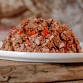 Rinder-Barf-Menü, gewolft, mit Gemüse und Früchten auf Teller.