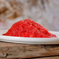Feiner roter Früchtemix aus Apfel, Johannisbeere und Birne, frisch geraspelt auf einem Teller.